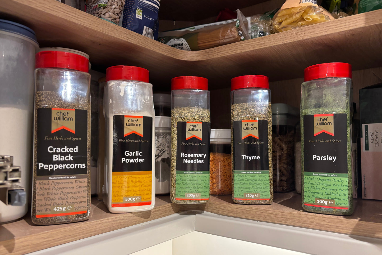 Spice jars on a kitchen shelf with visible labels