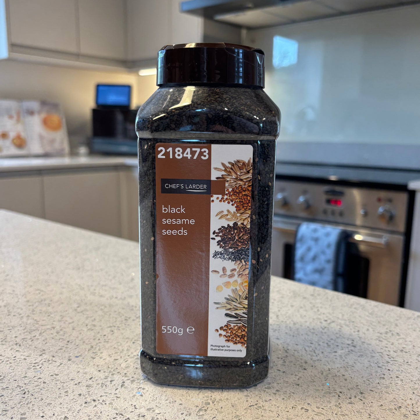 Bulk bottle of chef's larder black sesame seeds on a kitchen counter