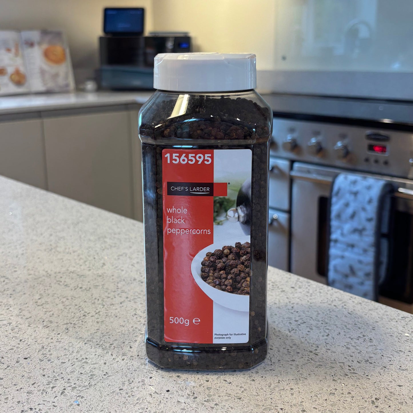 Bottle of Chef's Larder whole black peppercorns on a kitchen counter
