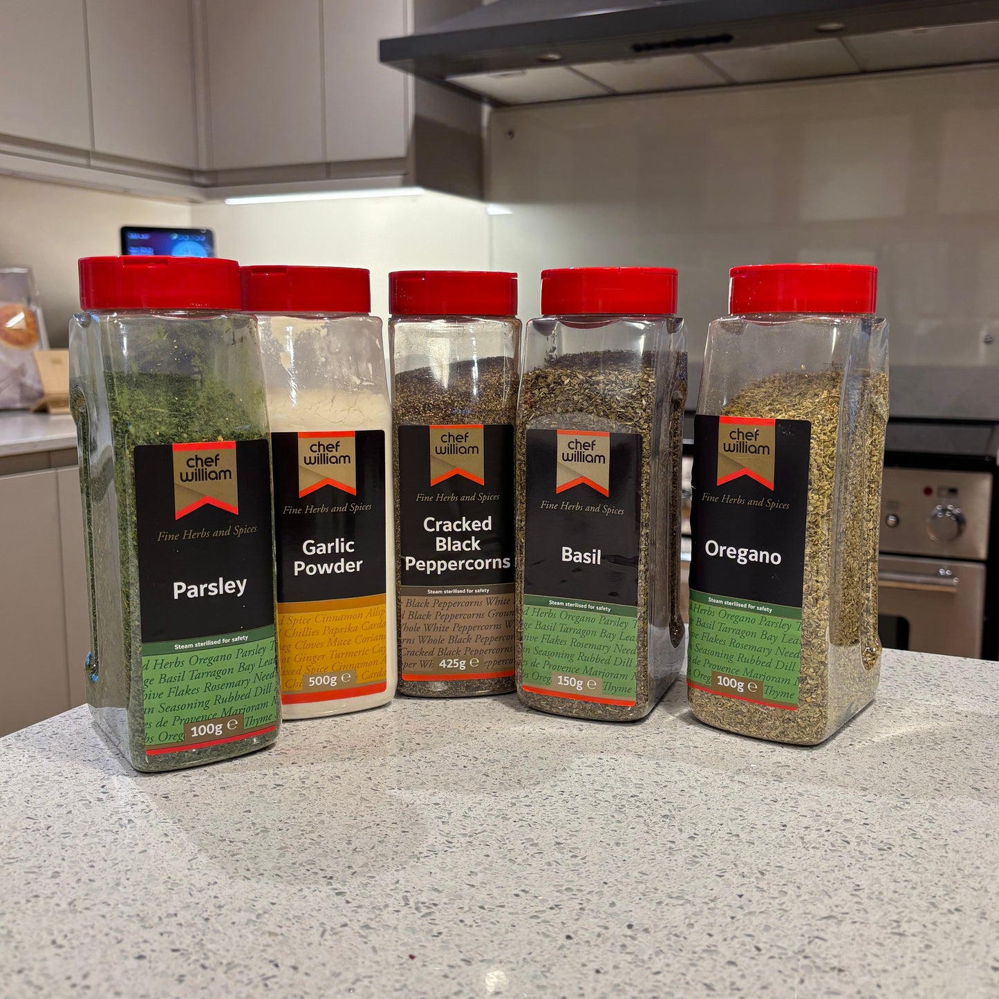 Chef William spice containers to make garlic and herb seasoning on a kitchen counter with a blurred background