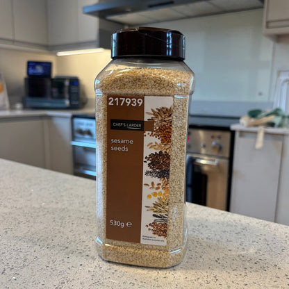 Spice jar of chef's larder sesame seeds on a kitchen counter with blurred background